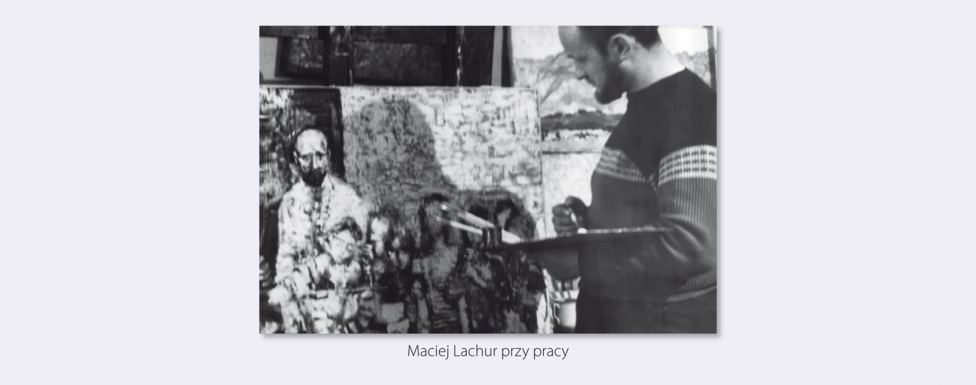 Czarno-biała fotografia archiwalna, przedstawiająca artystę w pracowni, stoi z paletą malarską przed jednym ze swoich obrazów.