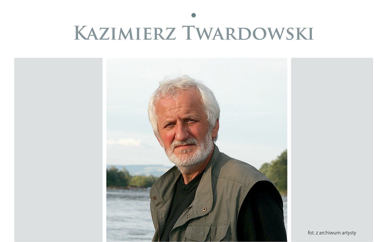 Kazimierz Twardowski. Zdjęcie portretowe - meżczyzna z siwymi włosami, wąsami i brodą, w tle jezioro.