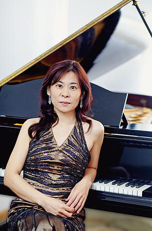 Japońska pianistka Mamiko Ueyama siedząca przed fortepianem