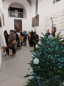 Zwiedzający w Kaplicy. Na pierwszym planie choinka ze światełkami