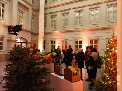 Grupa osób zwiedzających wystawę szopek