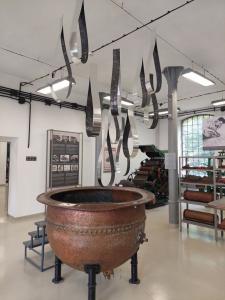 Instalacja przedstawiająca formy łez, wykonanych z blaszanych pasów, które wiszą nad zabytkową kadzią, znajdującą się na ekspozycji stałej w Starej Fabryce.