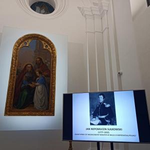 po lewej stronie duży obraz w złotej ramie, po prawej stronie rzutnik z wyświetloną prezentacją o Janie Nepomucenie Sułkowskim, w tle wnętrze Kaplicy