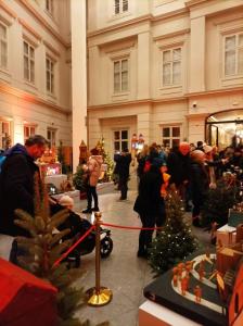 Grupa osób wraz z dziećmi zwiedzają wystawę szopek