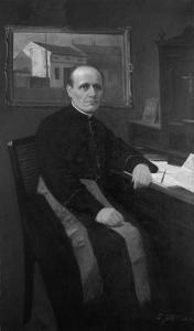 Ks. Stanisław Stojałowski siedzi przy sekretarzyku