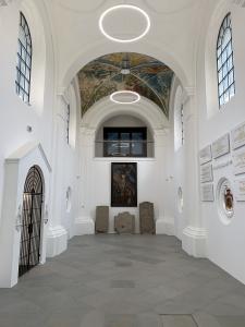 Wnętrze kaplicy, widok na emporę. Po lewej wejście, po prawej tablice pamiątkowe.