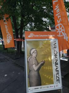 Plakat wystawy „Włókniarze”, skwerek przed Muzeum Techniki